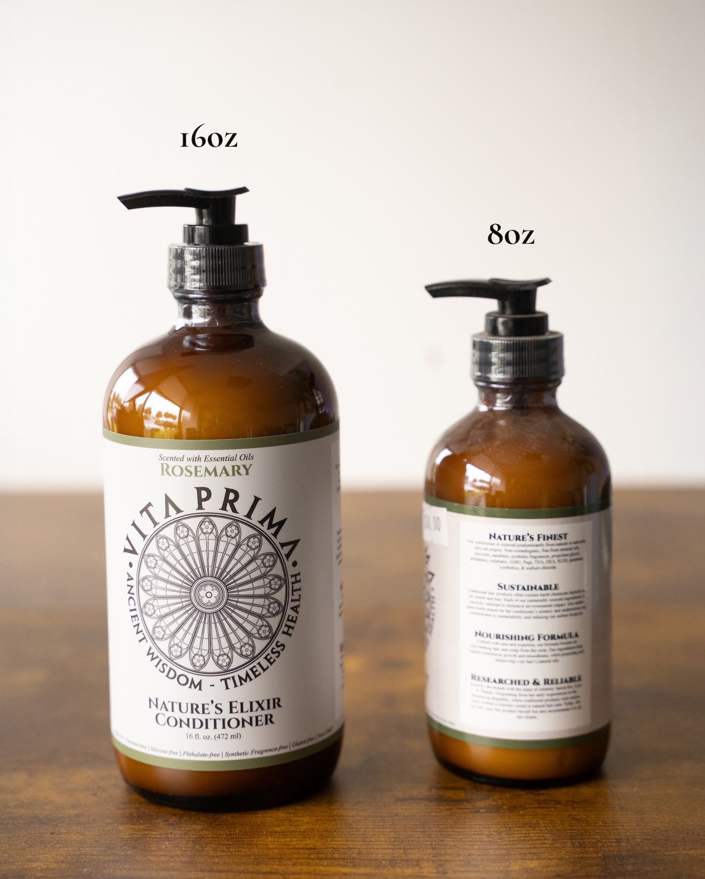 Two bottles of Vita Prima conditioner on a wooden surface with labels indicating 16oz and 8oz.