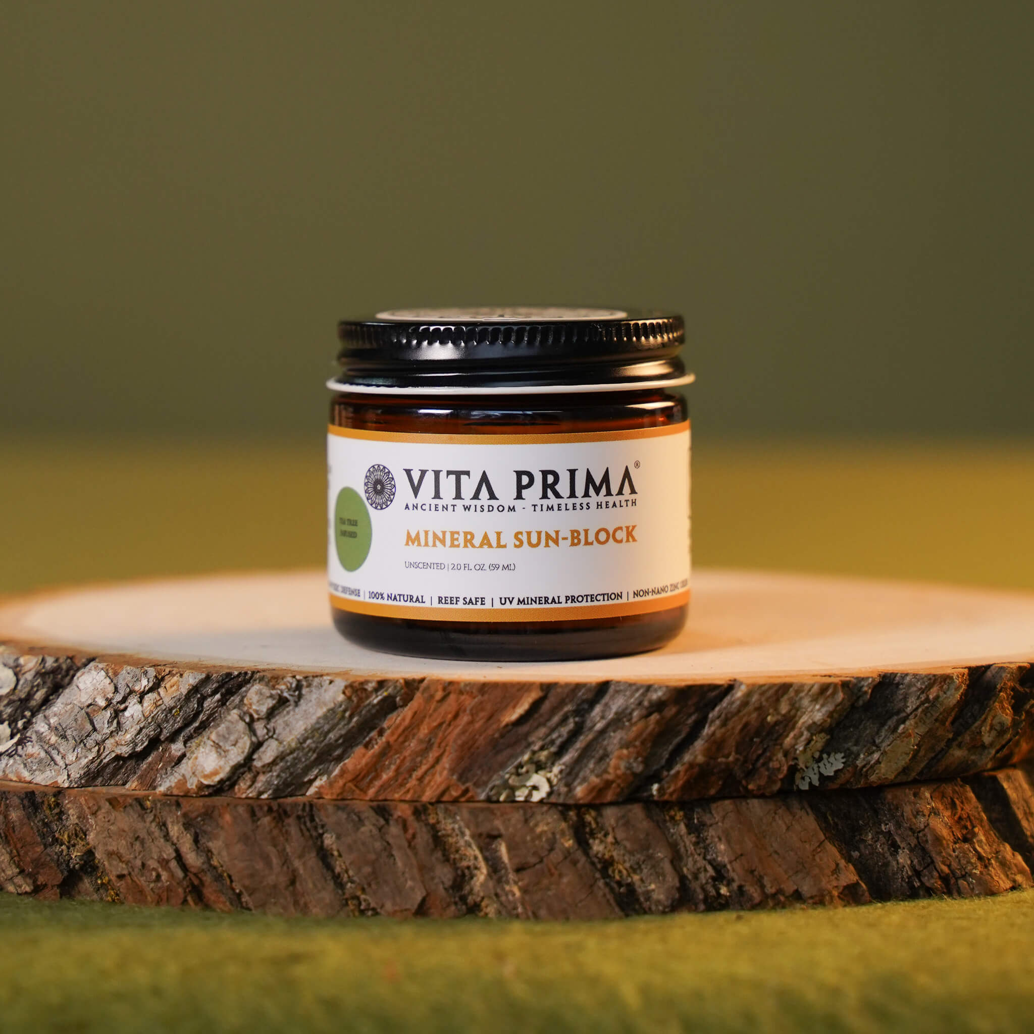 Vita Prima mineral sun block jar on a wooden surface with a green background
