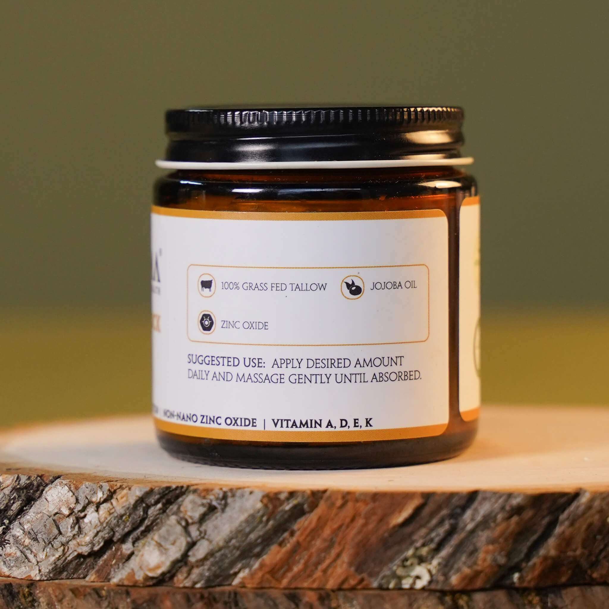 Jar of skincare product on a wooden surface with a green background