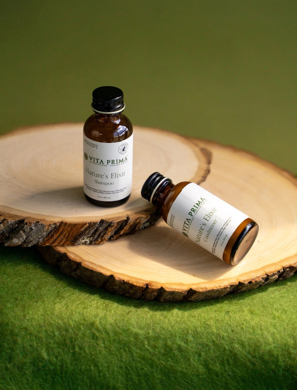 Two bottles of Vita Prima Nature's Elixir on a wooden surface with a green background