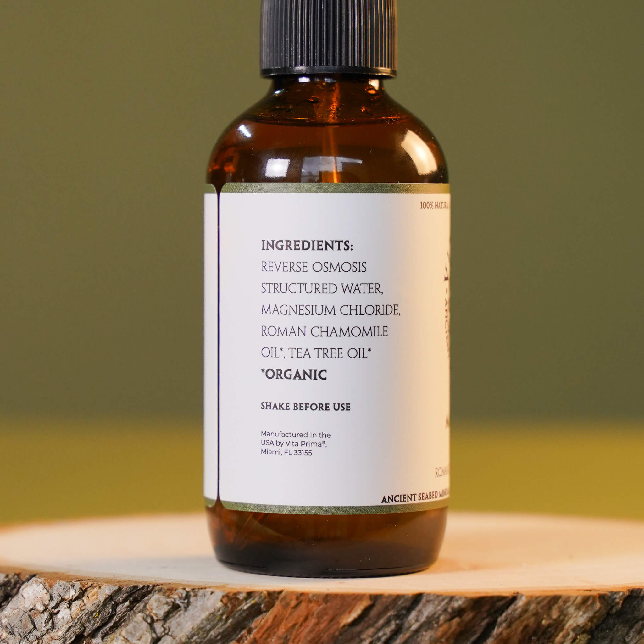 Bottle with a label on a wooden surface and green background